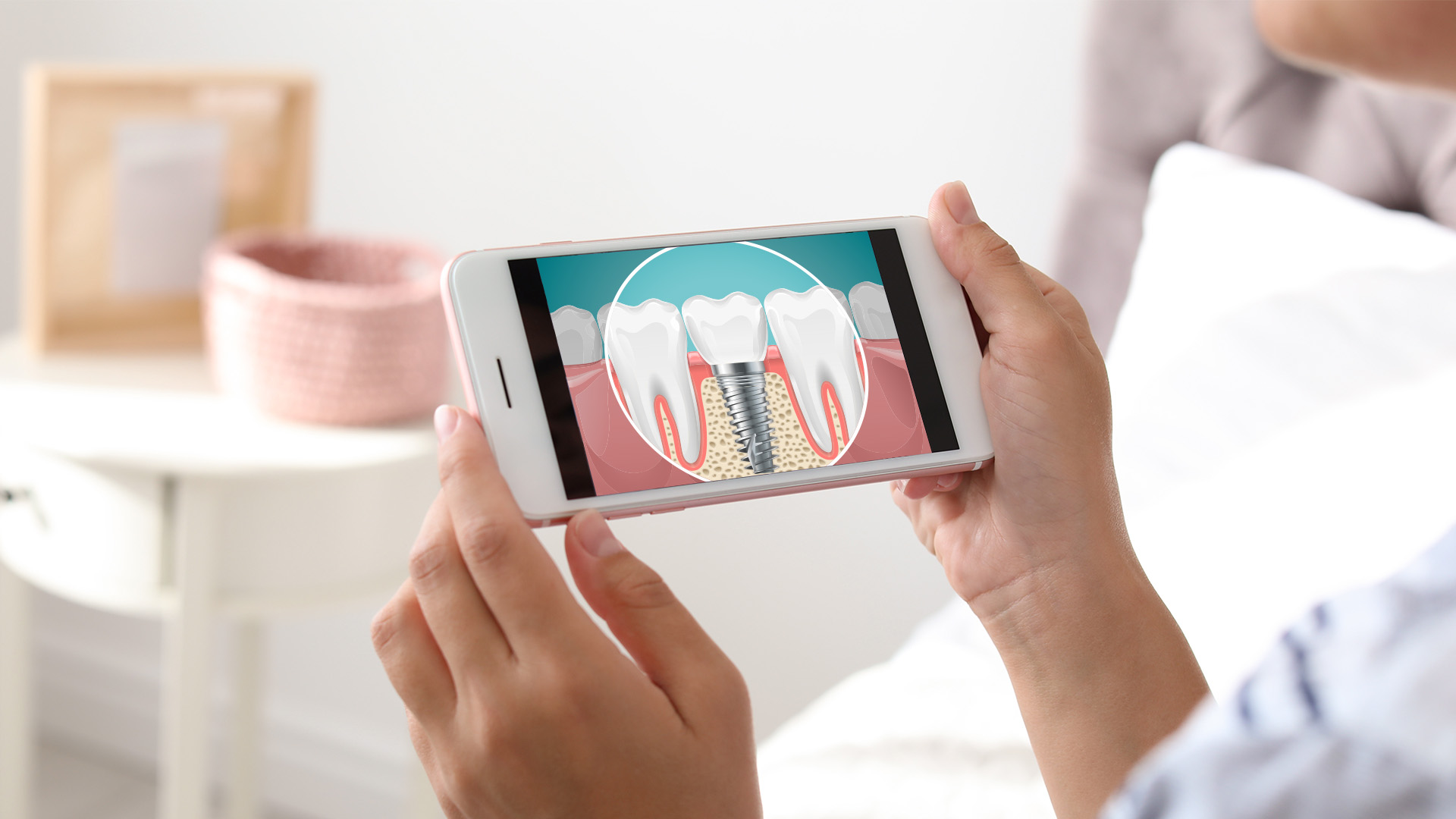 A person holding a smartphone displaying an image of a tooth with a cavity on a screen, possibly for dental health education or information.